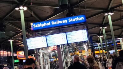 Schiphol Railway Station — rótulo azul + paneles NS