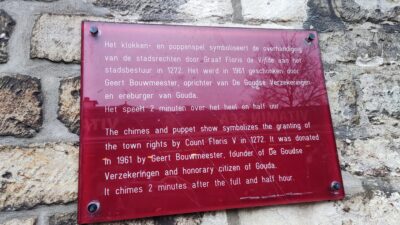 Placa explicativa del klokken- en poppenspel del Stadhuis