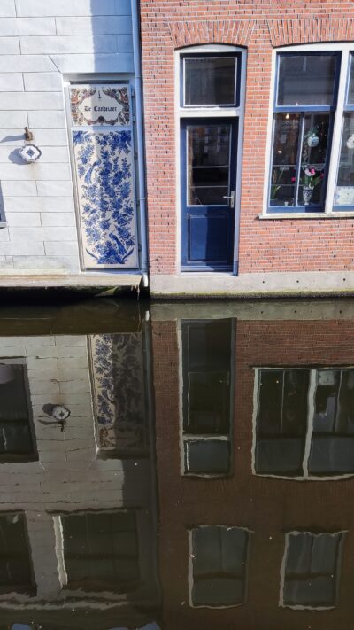 Delft — canal con mural de azulejos Delftware reflejado